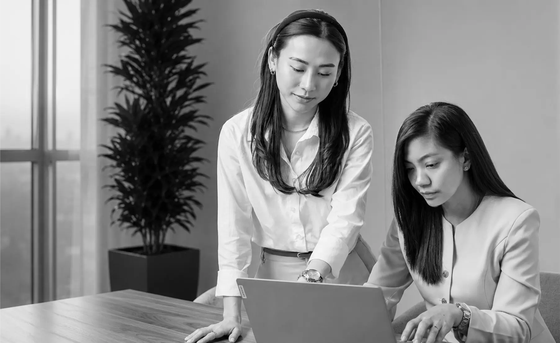 Colleagues collaborating at a laptop in a modern office — careers at De Dam Real Estate